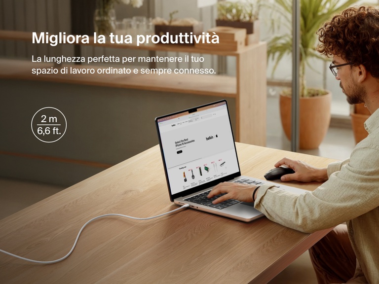 Man working at a desk with a laptop powered by the Belkin BoostCharge Pro USB-C to USB-C Braided Cable 240W, shown in a 2-meter (6.6 ft) length for an extended and clutter-free workspace.