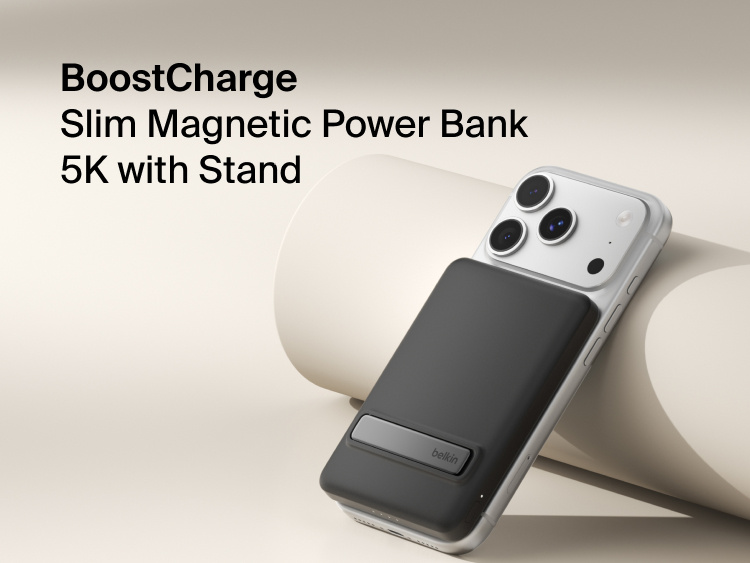 Belkin BoostCharge Slim Magnetic Power Bank 5K with Qi2 wirelessly attached to a smartphone, featuring a slim magnetic design with integrated card storage for portable on-the-go charging.