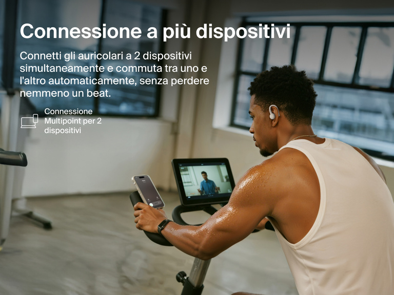 Belkin SoundForm ActiveFit Wireless Earbuds with multipoint 2-device connection, shown on a man using them while cycling on a stationary bike.