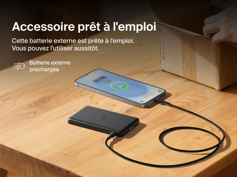 Belkin BoostCharge Slim Magnetic Power Bank 5K shown charging a smartphone on a table, highlighting its precharged battery ready for instant use out of the box.