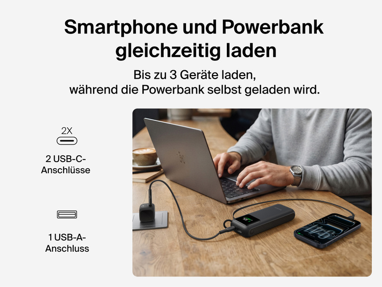 Die &zwnj;UltraCharge Powerbank 11K mit einziehbarem Kabel l&auml;dt gleichzeitig einen Laptop und ein Smartphone an einem Schreibtisch &uuml;ber das einziehbare Kabel, die USB-C-Anschl&uuml;sse und den USB-A-Anschluss.