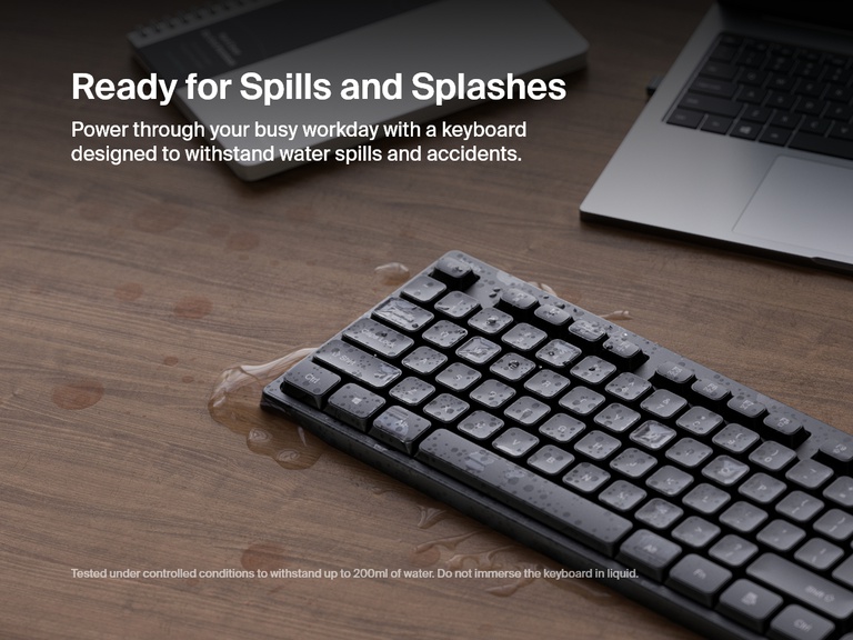 A Belkin Connect wireless keyboard is shown with water droplets on the keys and surface, demonstrating its spill-resistant design for everyday durability.