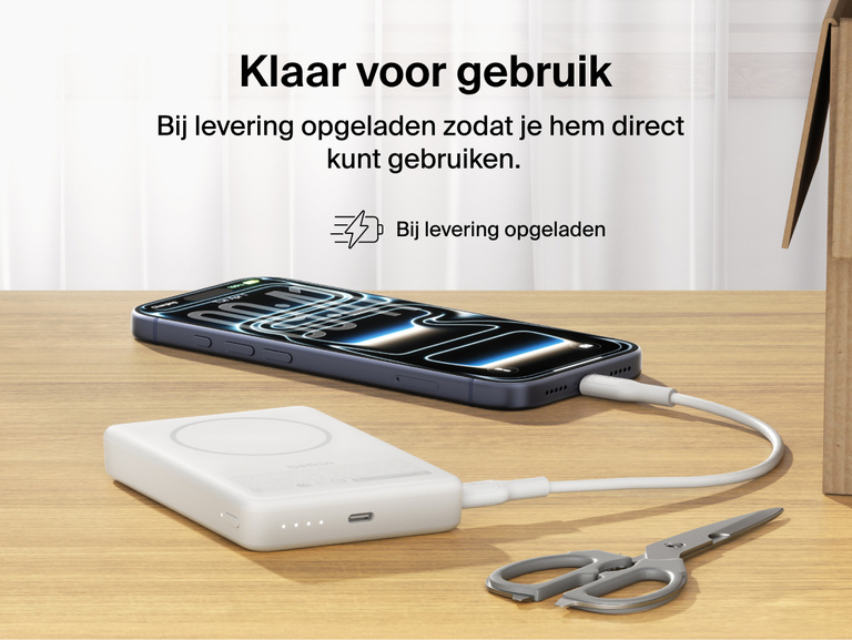 Slim Magnetic Power Bank 10K with Qi2 charging smartphone on desk with precharged battery indicator lights visible