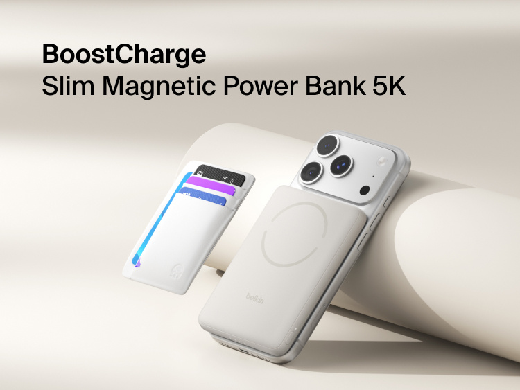Belkin BoostCharge Slim Magnetic Power Bank 5K with Qi2 wirelessly attached to a smartphone, featuring a slim magnetic design with integrated card storage for portable on-the-go charging.