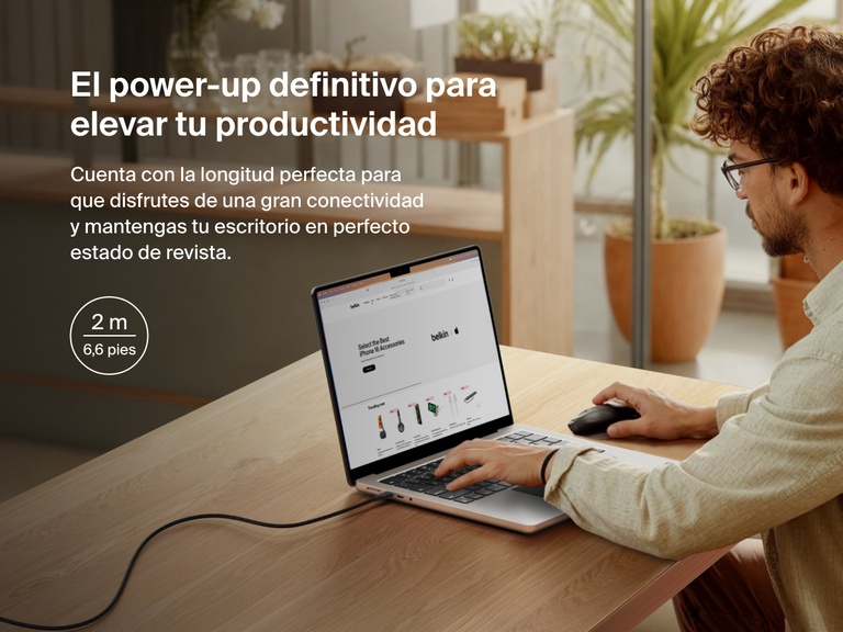 Man working at a desk with a laptop powered by the Belkin BoostCharge Pro USB-C to USB-C Braided Cable 240W, shown in a 2-meter (6.6 ft) length for an extended and clutter-free workspace.