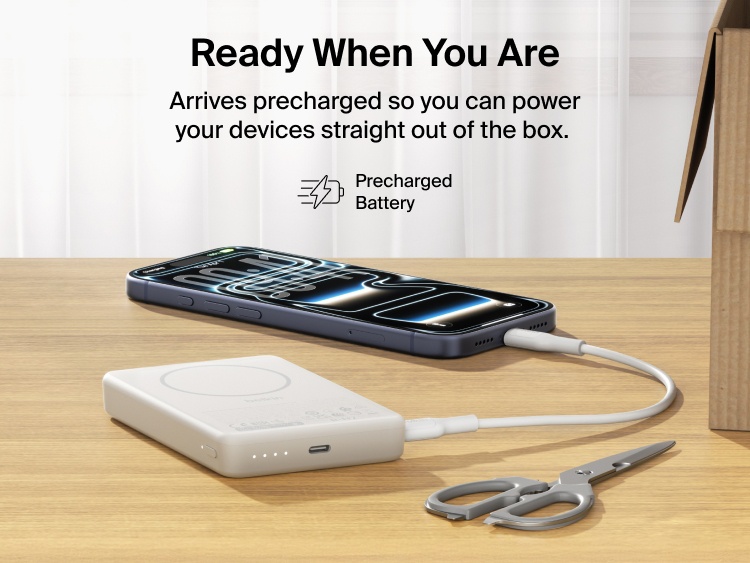Belkin BoostCharge Slim Magnetic Power Bank 10K charging iPhone via USB-C on desk showing precharged battery ready for immediate use