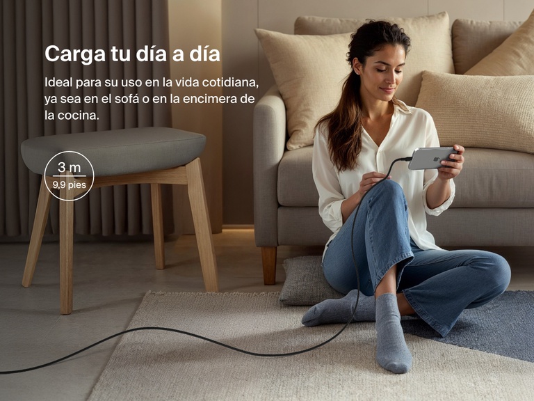 Woman sitting on the floor using a phone connected to the Belkin BoostCharge Pro USB-C to USB-C Braided Cable 240W, shown in a 3-meter (9.9 ft) length for everyday charging flexibility.