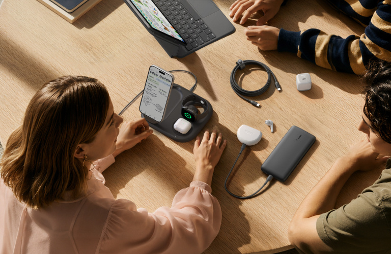 Belkin charging products, earbuds and cables arranged on a table as students gather with their devices for back-to-school.