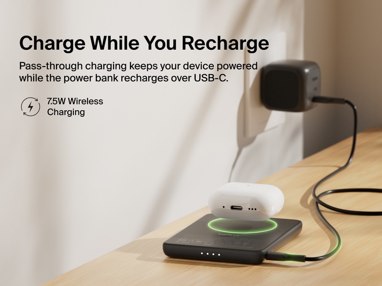 Belkin BoostCharge Slim Magnetic Power Bank 5K shown wirelessly charging earbuds while recharging via USB-C, demonstrating 7.5W pass-through charging functionality.
