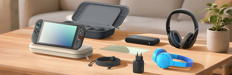 Une console Nintendo Switch 2 est posée sur une pochette de transport colorée, toutes deux sur une table en bois. Un chargeur secteur se trouve à proximité ainsi qu'une pochette de rangement gris foncé avec les compartiments de rangement pour cartes de jeux visibles. Une protection d'écran est posée à plat sur un bureau, ce qui permet de montrer l'ensemble d'accessoires pour gaming, dans une salle éclairée.