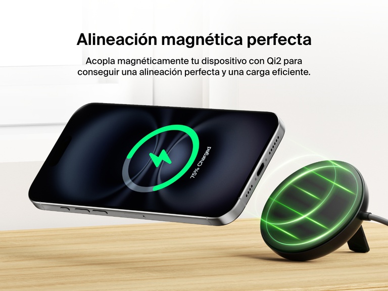 Se muestra una base magnética de carga inalámbrica con Qi2 de 15 W BoostCharge Pro de Belkin de color negro, sobre una superficie de madera y alineándose magnéticamente con un iPhone para garantizar una carga inalámbrica eficiente. 