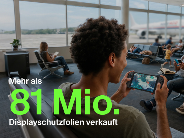 Eine junge Person spielt im Gatebereich eines Flughafens lächelnd ein Spiel auf einer Nintendo Switch 2. Im Hintergrund sitzen weitere Reisende, die lesen oder ihre Smartphones benutzen, und durch das Fenster ist ein Flugzeug zu sehen. Im Vordergrund steht in großer grüner Schrift „Über 81 Mio.” und darunter in weißer Schrift „Displayschutzfolien verkauft“, um die Beliebtheit des Produkts zu veranschaulichen.