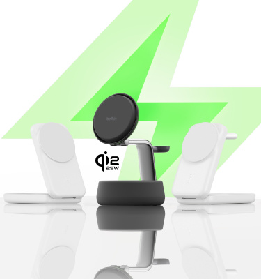 Drie draadloze laadstations van Belkin staan op een reflecterend oppervlak, twee witte modellen links en rechts van een zwart model, met een grote groene bliksemschicht op de achtergrond en de tekst “Qi2 25W” naast de middelste lader.