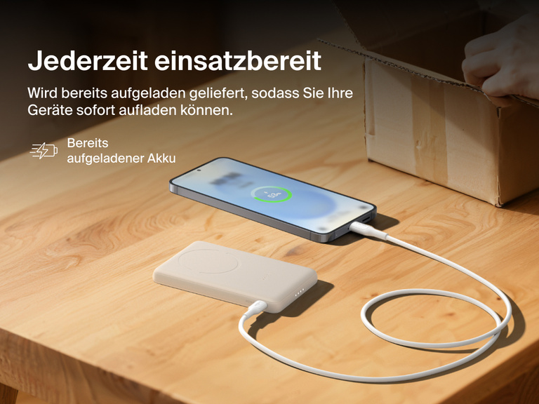 Belkin BoostCharge Slim Magnetic Power Bank 5K shown charging a smartphone on a table, highlighting its precharged battery ready for instant use out of the box.