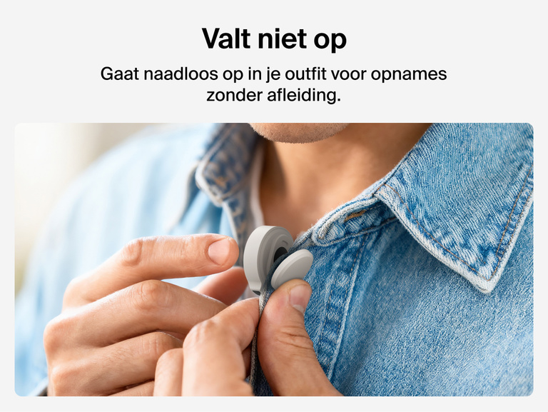 Een persoon klemt een kleine minimalistische draadloze microfoon vast aan de kraag van een lichte spijkerblouse. De tekst links luidt &ldquo;Valt niet op&rdquo; en beschrijft hoe de microfoon naadloos in kleding opgaat voor opnemen zonder afleiding.