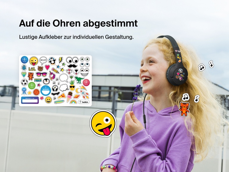 Smiling girl wearing Belkin Wired On-Ear Headphones for Kids decorated with colorful stickers, highlighting the headset’s personalization feature with included fun sticker sheet.