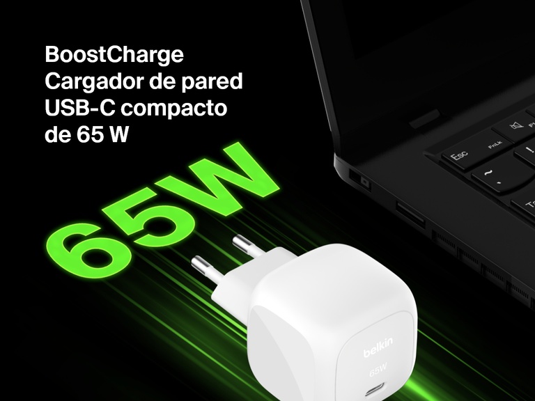 Imagen en ángulo del cargador de pared compacto USB-C de 65 W Belkin BoostCharge junto a un portátil, en la que se destaca su capacidad de carga rápida con el texto en negrita verde «65 W» para enfatizarlo.