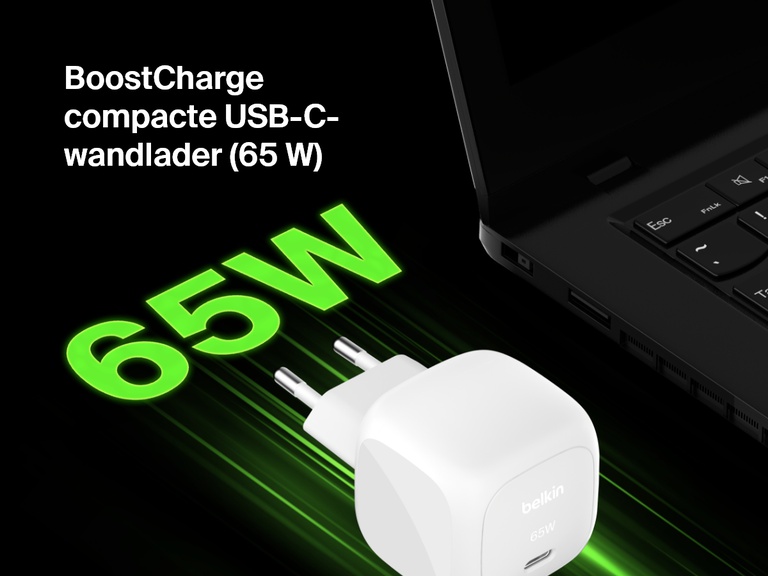 Afbeelding van de Belkin BoostCharge compacte 65 W USB-C-wandladerr naast een laptop, waarin de snellaadfunctie benadrukt wordtmet de dikgedrukte groene tekst “65 W”.