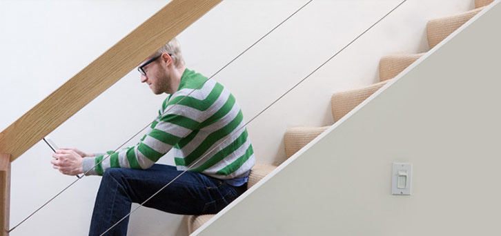 Homme assis sur des escaliers utilisant un ordinateur portable