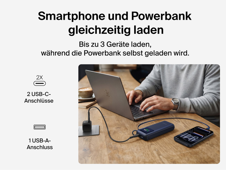 Die &zwnj;UltraCharge Powerbank 11K mit einziehbarem Kabel l&auml;dt gleichzeitig einen Laptop und ein Smartphone an einem Schreibtisch &uuml;ber das einziehbare Kabel, die USB-C-Anschl&uuml;sse und den USB-A-Anschluss.