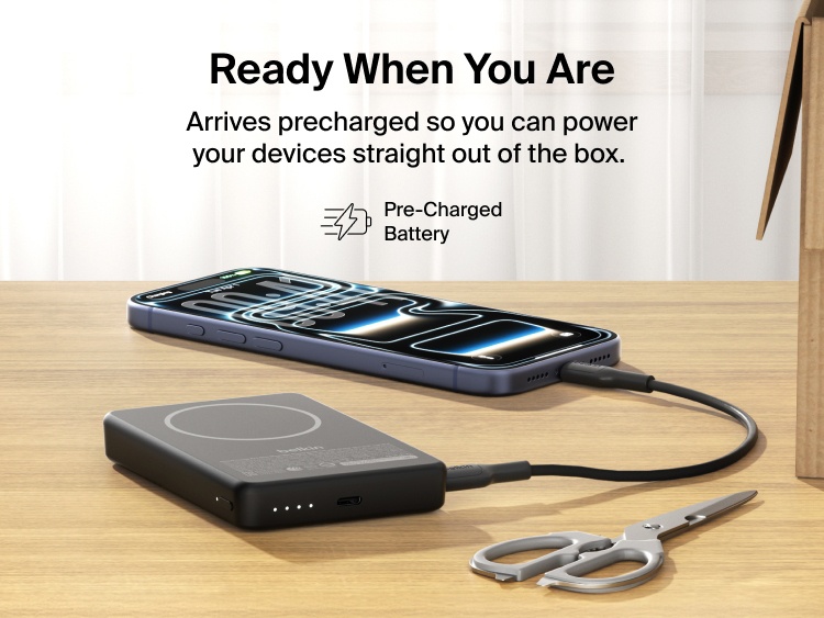 Slim Magnetic Power Bank 10K with Qi2 charging smartphone on desk with precharged battery indicator lights visible