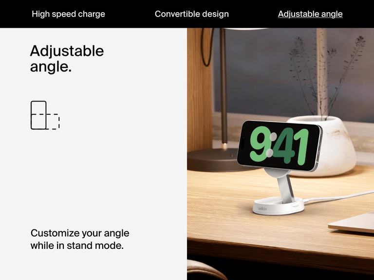 A white Belkin BoostCharge Pro Convertible Magnetic Wireless Charging Stand with Qi2 15W holds a horizontally oriented iPhone on a desk, illustrating its adjustable viewing angle in stand mode.