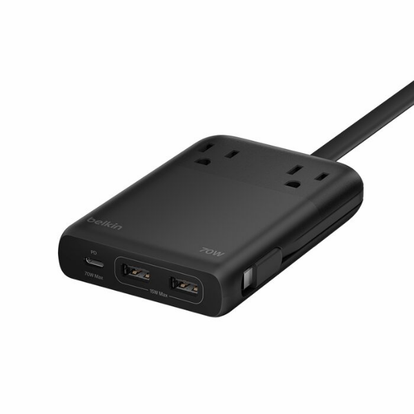 A black Belkin charging station with two AC outlets on top, one built-in USB-C cable stored along the side, and two USB-A ports plus one USB-C port on the front. The unit has a slim, rectangular design with rounded edges and an attached power cord.