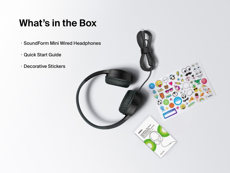 Flat lay image showing the contents of the Belkin SoundForm Mini Wired Headphones box, including the headphones, a quick start guide, and a sheet of decorative stickers.