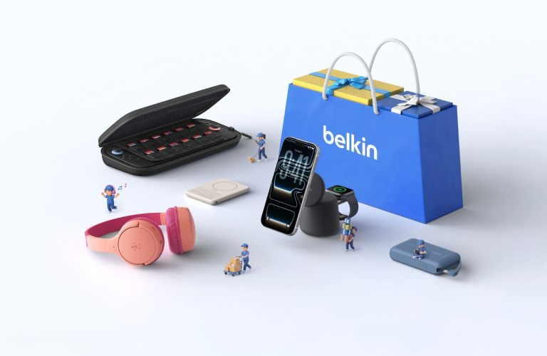 Belkin charging accessories and mobile devices displayed around a branded shopping bag with miniature workers, showcasing portable power, wireless charging, and everyday tech essentials.