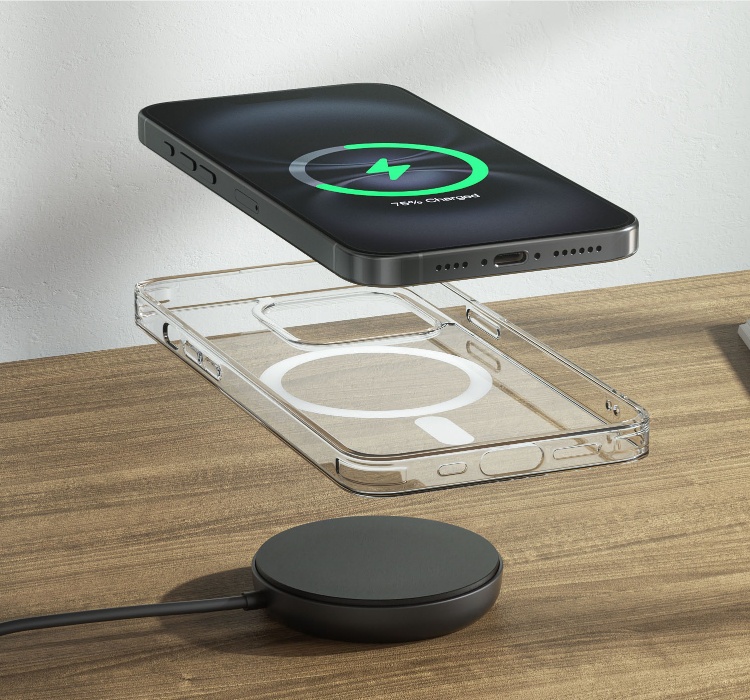 Ein schwarzes kabelloses MagSafe-Ladegerät auf einem Nachschränkchen aus Holz. Ein Smartphone mit einem Ladesymbol schwebt in der Luft darüber. Unter dem Telefon, auch in der Luft, eine transparente MagSafe-kompatible Hülle, deren magnetsicher Ring zu sehen ist. An der rechten Seite liegt ein aufgeschlagenes Buch. Auf die weiße Wand im Hintergrund wird ein sanfter Schatten geworfen.