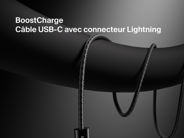 Gros plan d'un câble USB-C Belkin BoostCharge avec connecteur Lightning, doté d'une gaine tressée résistante et enroulé sur un fond sombre pour souligner son design haut de gamme et sa compatibilité avec la charge rapide des appareils Apple.