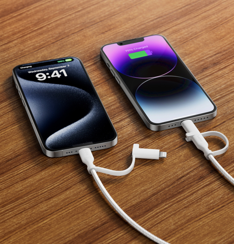 Deux iPhone sur une surface en bois, rechargés avec le câble 2-en-1 BoostCharge Pro.