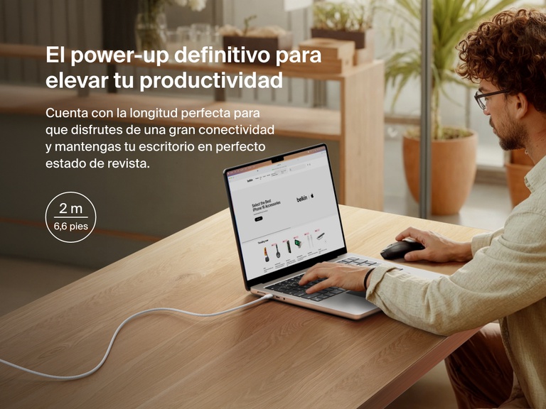 Man working at a desk with a laptop powered by the Belkin BoostCharge Pro USB-C to USB-C Braided Cable 240W, shown in a 2-meter (6.6 ft) length for an extended and clutter-free workspace.