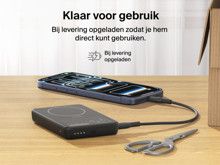 Belkin BoostCharge Slim Magnetic Power Bank 10K charging iPhone via USB-C on desk showing precharged battery ready for immediate use