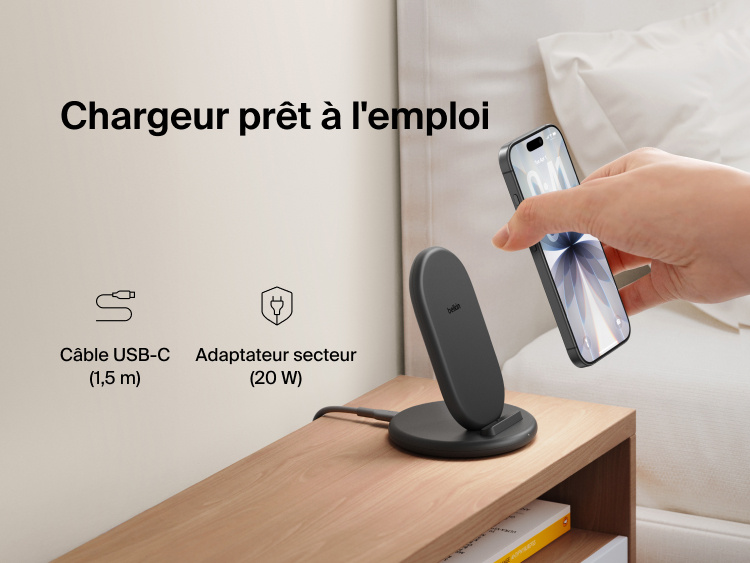 Belkin BoostCharge Wireless Charging Stand 15W shown on a bedside table with smartphone, includes 5ft USB-C cable and 20W power adapter for immediate charging out of the box.