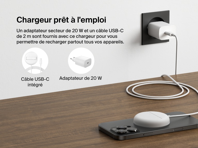 Image montrant la station de recharge sans fil blanche Belkin BoostCharge Pro avec Qi2 (15 W)  posée sur un bureau, qui recharge un iPhone et qui met en avant son adaptateur secteur (20 W) et son cable USB-C intégré (2 m).