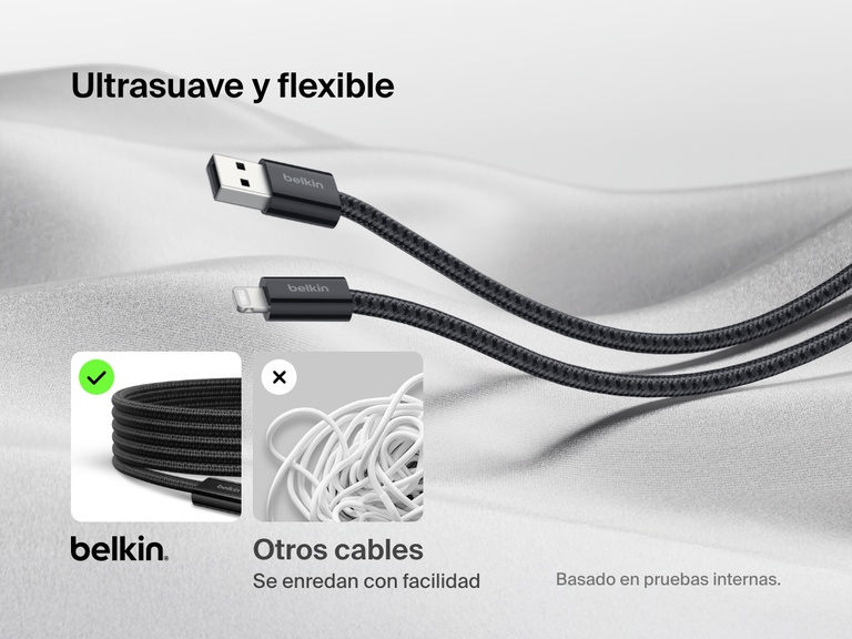 Cable Belkin BoostCharge USB-A con conector Lightning mostrado sobre un tejido suave, destacando su diseño trenzado ultraflexible antienredos en comparación con los cables estándar que se enredan con facilidad.