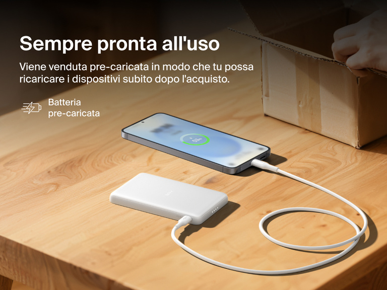 Belkin BoostCharge Slim Magnetic Power Bank 5K shown charging a smartphone on a table, highlighting its precharged battery ready for instant use out of the box.