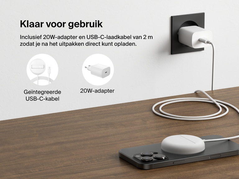 Afbeelding van een wit Belkin BoostCharge Pro magnetisch draadloos laadstation met Qi2 (15 W) die een iPhone oplaadt op een bureau, waarmee de meegeleverde 20W-voedingsadapter en de vaste USB-C-voedingskabel voor direct gebruik geïllustreerd worden.