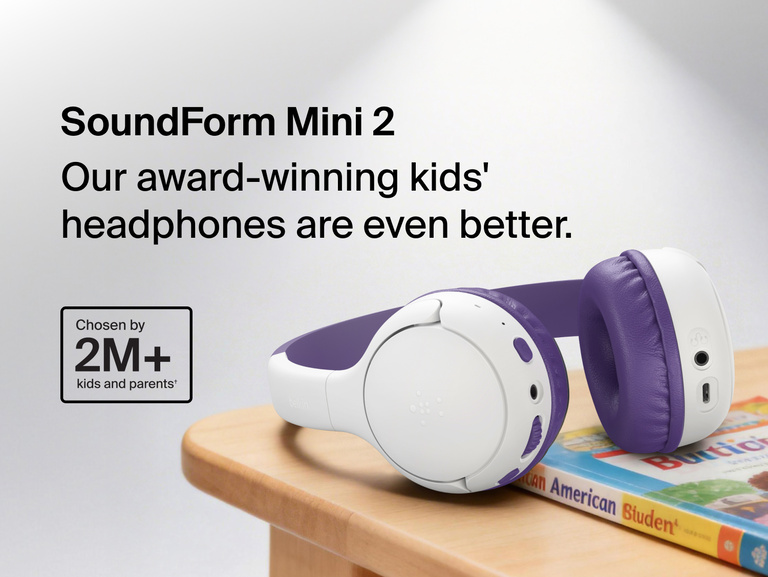 SoundForm Mini 2 Wireless On-Ear Headphones for Kids resting on a wooden surface beside a children's book, with on-image text reading Our award-winning kids' headphones are even better and Chosen by 2M+ kids and parents