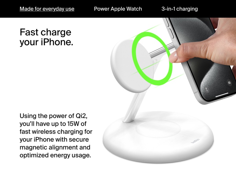 Image of a hand placing an iPhone onto a white Belkin BoostCharge Pro 3-in-1 Magnetic Wireless Charging Stand with Qi2 15W, illustrating secure magnetic alignment and fast charging up to 15W using Qi2 technology.