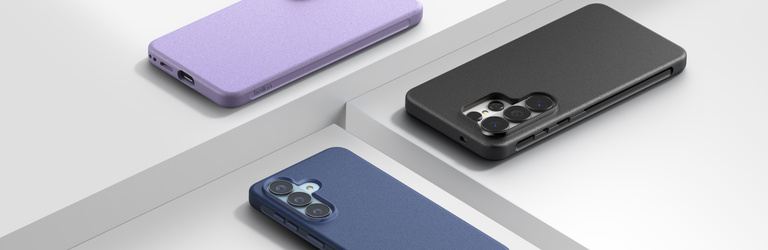 Three Samsung smartphones displayed face down in purple, black, and blue protective cases, arranged on a clean white platform background to showcase different case color options.