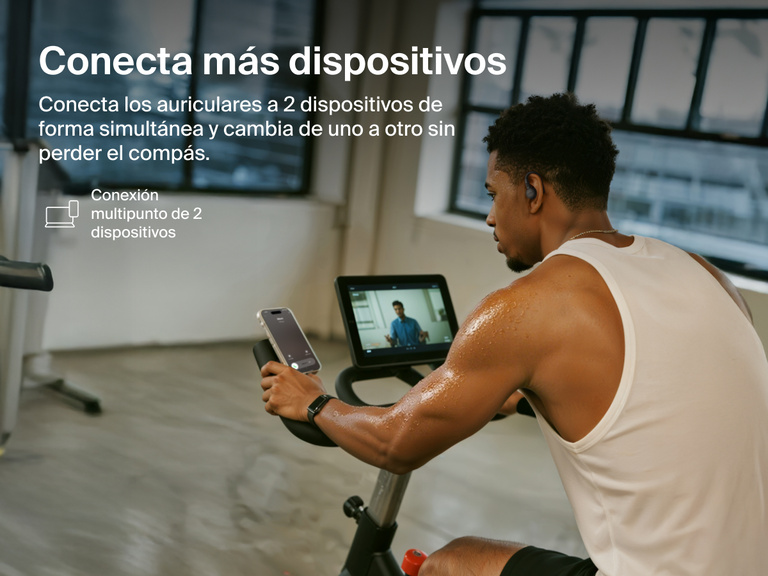 Belkin SoundForm ActiveFit Wireless Earbuds with multipoint 2-device connection, shown on a man using them while cycling on a stationary bike.