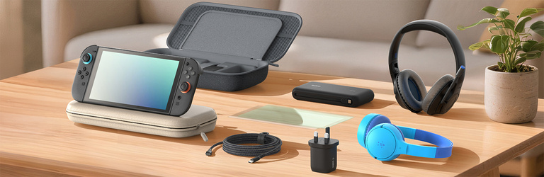 A Nintendo Switch 2 console is propped on a light-colored protective carrying case atop a wooden desk. Nearby, a black wall charger stands upright, and an open dark gray storage case with compartments is visible in the background. A screen protector lies flat on the desk, completing the setup of essential gaming accessories in a clean, well-lit room.