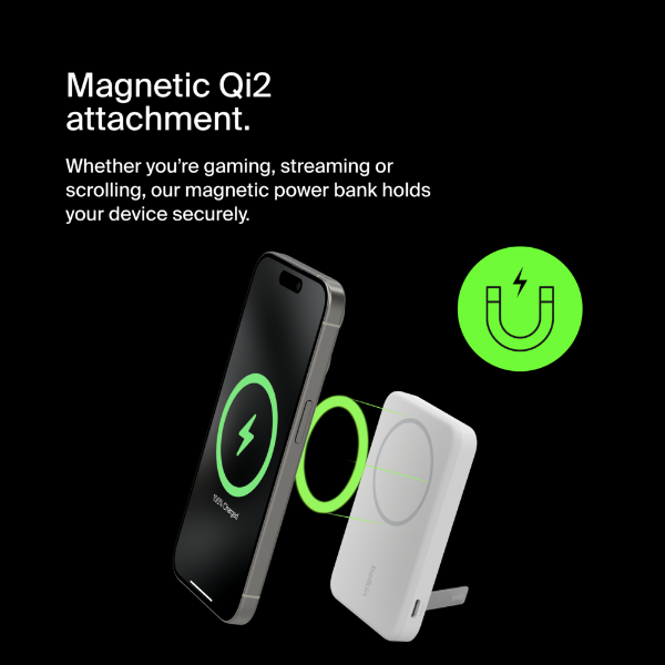 This image features a magnetic power bank using Qi2 wireless charging technology, showcased in an interaction with a smartphone. The text highlights "Magnetic Qi2 attachment," emphasizing the secure hold for gaming, streaming, or scrolling. A glowing green charging symbol on the phone's screen and a green magnet icon reinforce the magnetic and charging capabilities. The sleek white power bank with a circular magnetic surface is designed for seamless attachment to compatible devices. The black background adds a modern and high-tech feel.