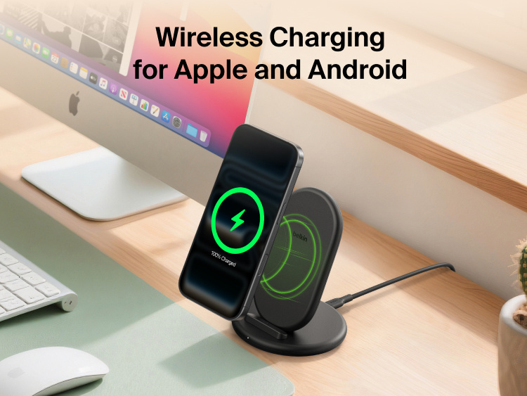 Belkin BoostCharge Wireless Charging Stand 15W shown charging a smartphone on a desk, compatible with both Apple and Android devices.