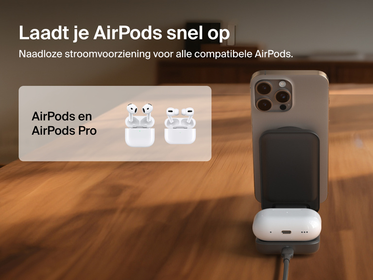 Afbeelding van de Belkin UltraCharge 2-in-1 uitklapbare magnetische lader met Qi2 25W die een iPhone en AirPods oplaadt op een houten oppervlak. De lader is geschikt voor AirPods en AirPods Pro.