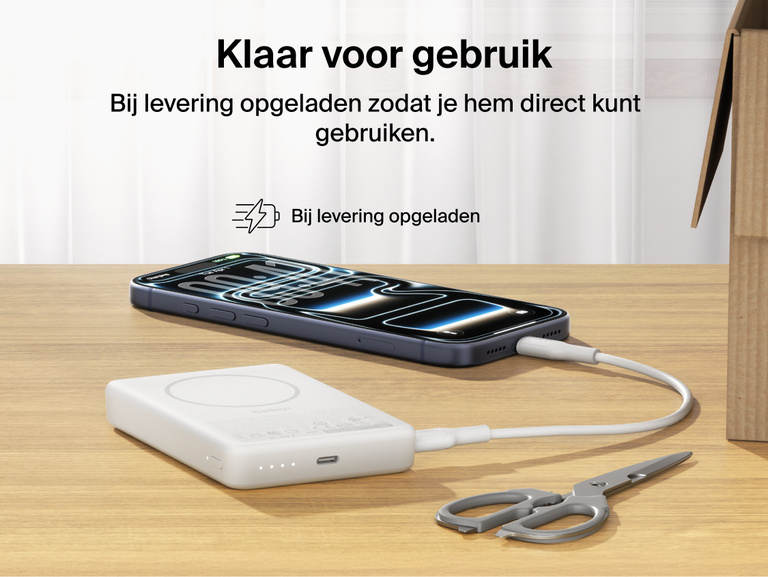 Belkin BoostCharge Slim Magnetic Power Bank 10K precharged out of the box powering a smartphone via USB-C cable with portable battery placed on a desk