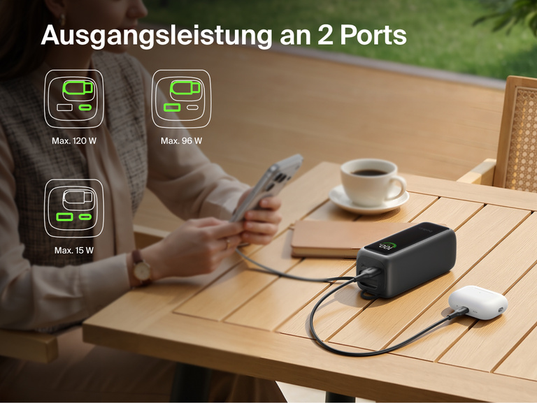 UltraCharge Powerbank 22K mit einziehbarem Kabel, die an einem Tisch ein Smartphone und ein Ladecase f&uuml;r In-Ear-Kopfh&ouml;rer &uuml;ber zwei Anschl&uuml;sse gleichzeitig l&auml;dt, mit Symbolen f&uuml;r die verf&uuml;gbaren Leistungskombinationen.
