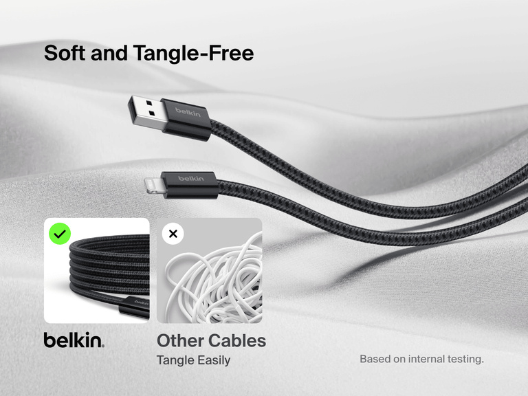 Belkin BoostCharge USB-A Cable with Lightning Connector shown on soft fabric, highlighting its ultra-flexible, tangle-free braided design compared to easily tangled standard cables.